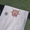 Passport Belt Flag for Belegarth Silver Jubilee - Close up of belt flag on black leather belt against a green tunic backgroup