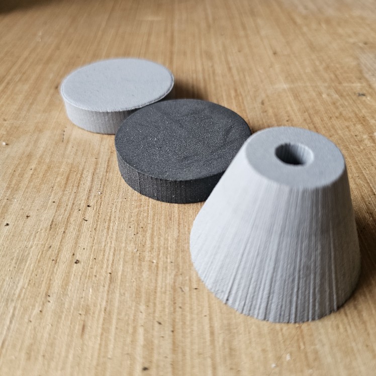 Pommel Kits (3/8" ID) 6lb gumdrop, 4lb disc, and 2lb disc lined up like a train on a wooden table